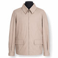 A light beige zip-up jacket with a pointed collar and two front flap pockets, displayed on a black mannequin torso against a white background.