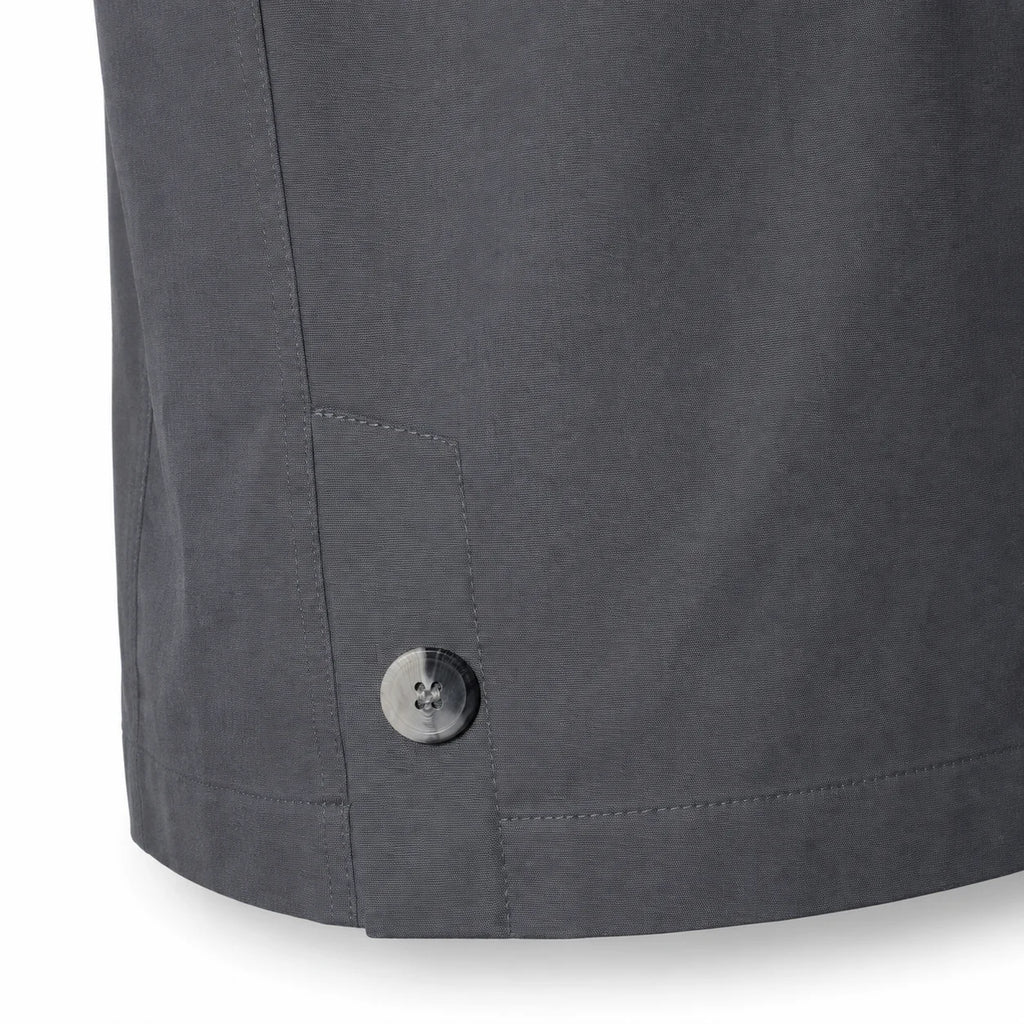 Close-up of a dark grey Durburg  Mistral showing the lower hem, a side pocket seam, and a single metallic button on a white background.