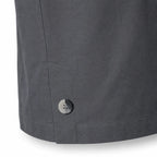Close-up of a dark grey Durburg  Mistral showing the lower hem, a side pocket seam, and a single metallic button on a white background.