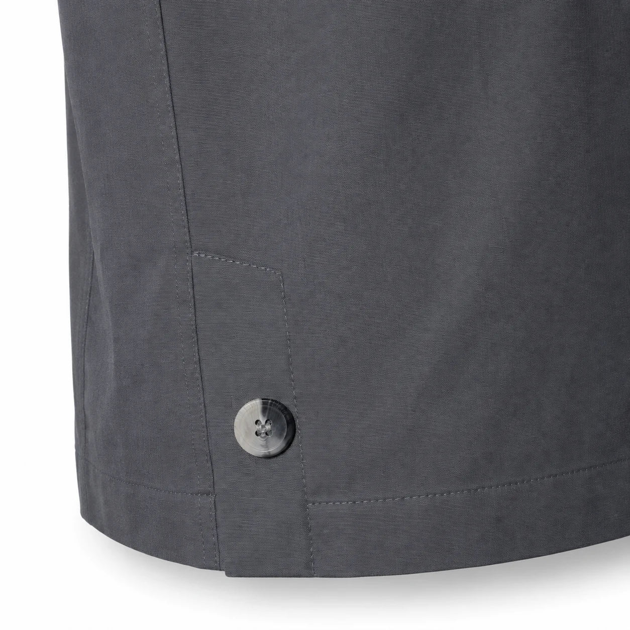 Close-up of a dark grey Durburg  Mistral showing the lower hem, a side pocket seam, and a single metallic button on a white background.