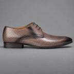 A single men's oxford dress shoe in distressed metallic bronze-brown leather with perforated detailing, shown in a side profile against a solid gray background.