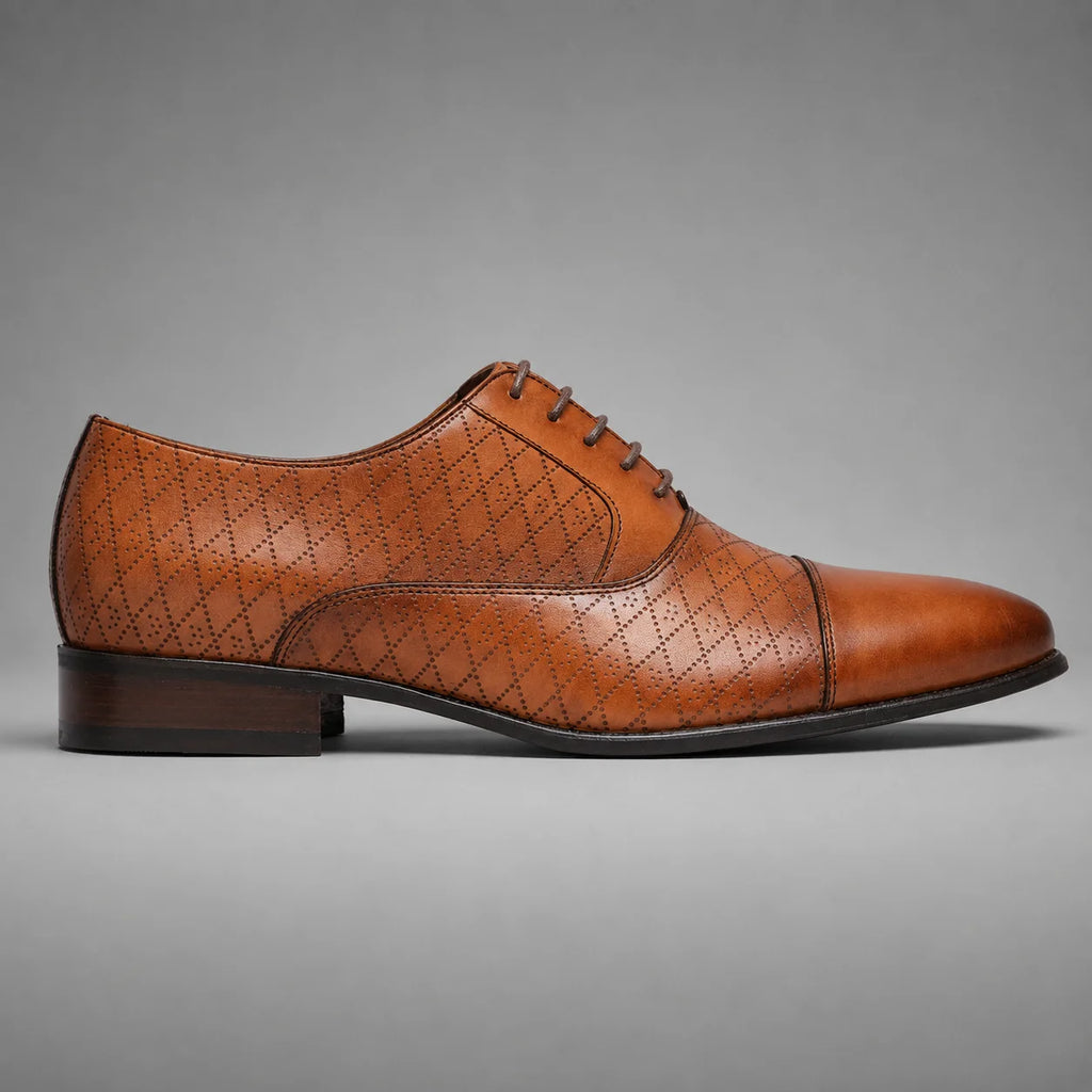 A single brown leather lace-up dress shoe with a cap toe and embossed geometric pattern, shown in profile against a neutral gray background.